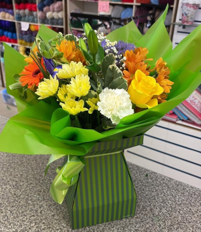 Golden Zest - A vibrant bouquet filled with sunny yellows and lively orange tones, complemented by fresh green foliage.