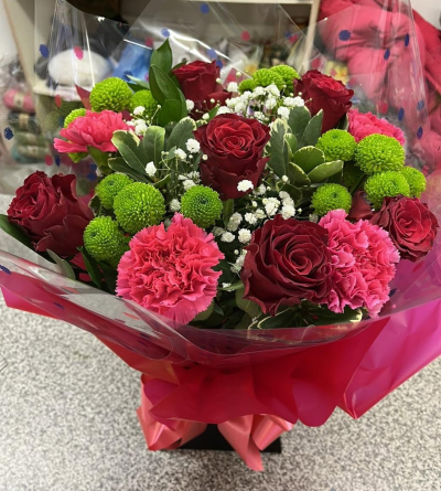 Ruby Rush - A striking bouquet of deep ruby reds and vibrant pinks, contrasted with fresh green and delicate white accents.
